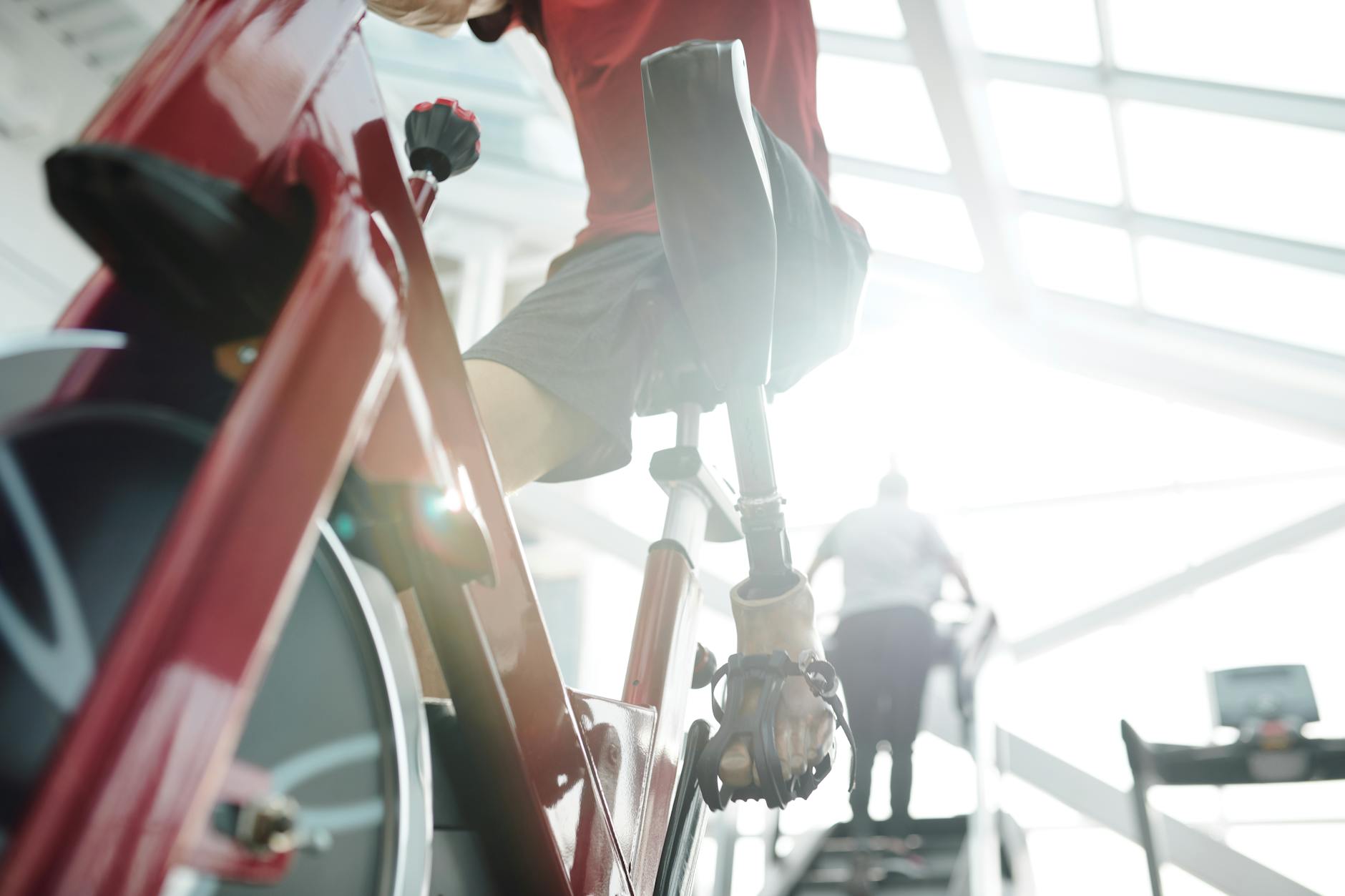 man in red t shirt riding a stationary bike